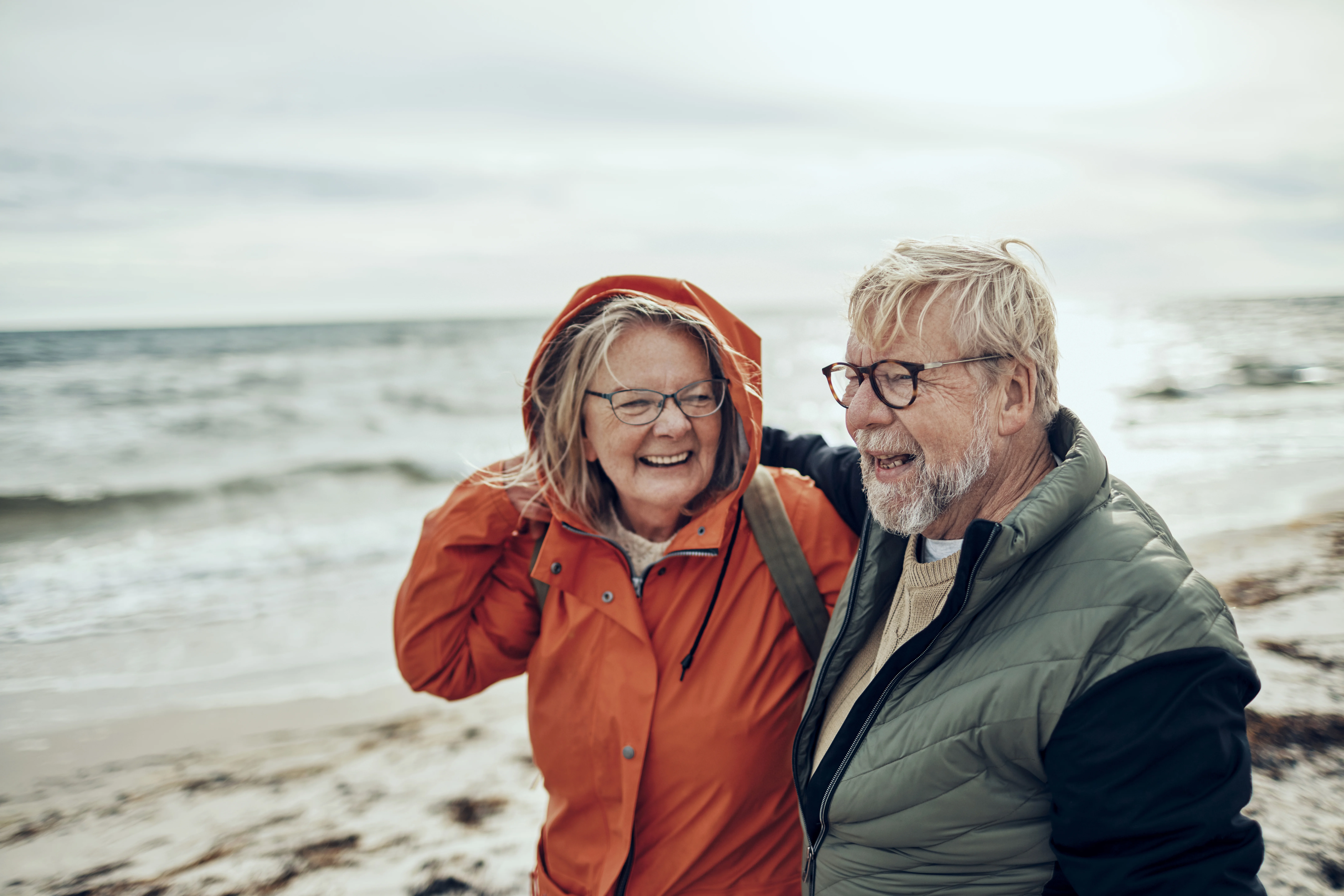 um homem e uma mulher em pé em uma praia